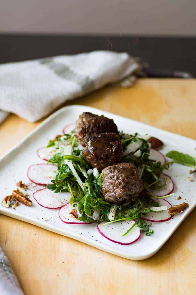 Keto meatballs on a plate with veggies.