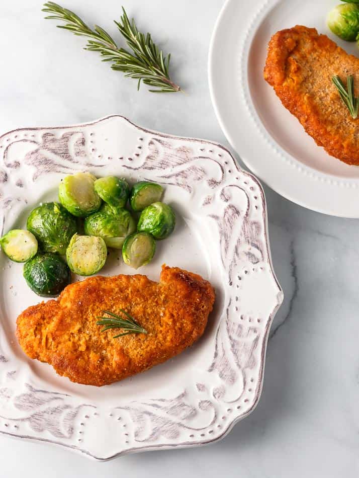 Keto shake and bake pork chops on a white plate.
