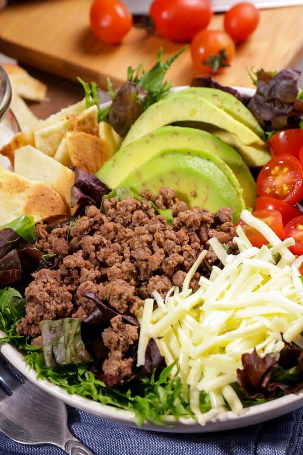 Keto taco salad on a bowl next to a fork.