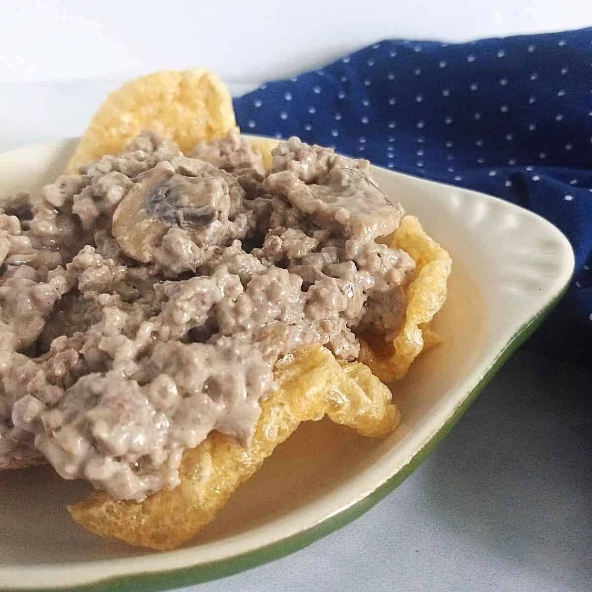 Keto beef stroganoff on a white plate next to a blue cloth.
