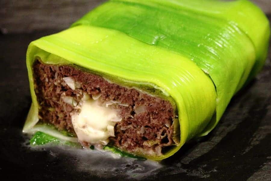 Keto cheese-stuffed meatloaf on a dark surface.