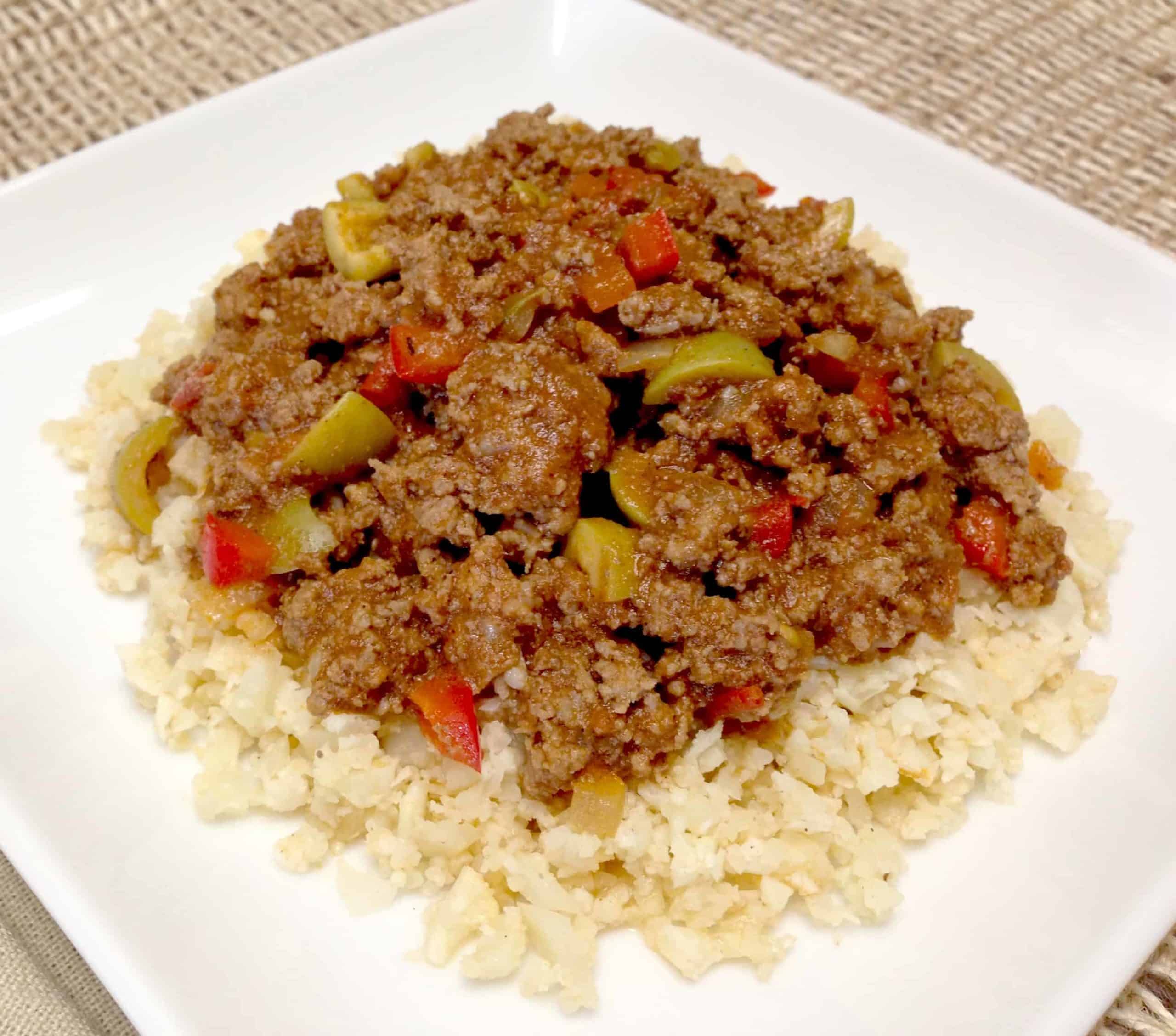 Cauliflower picadillo cuban ground beef with rice on a white plate.
