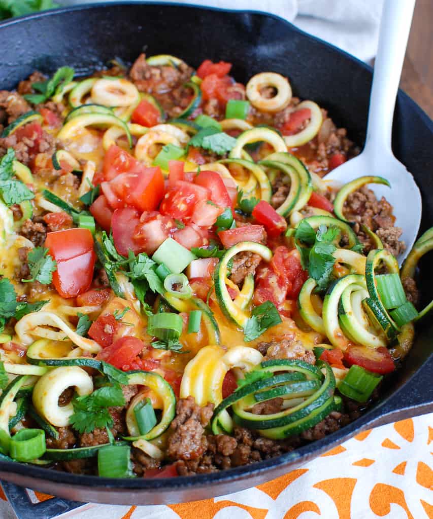 Mexican zucchini noodles in a pan with a spoon.