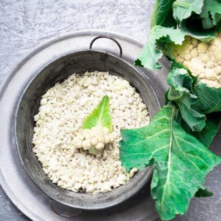 Uncooked cauliflower rice in strainer.