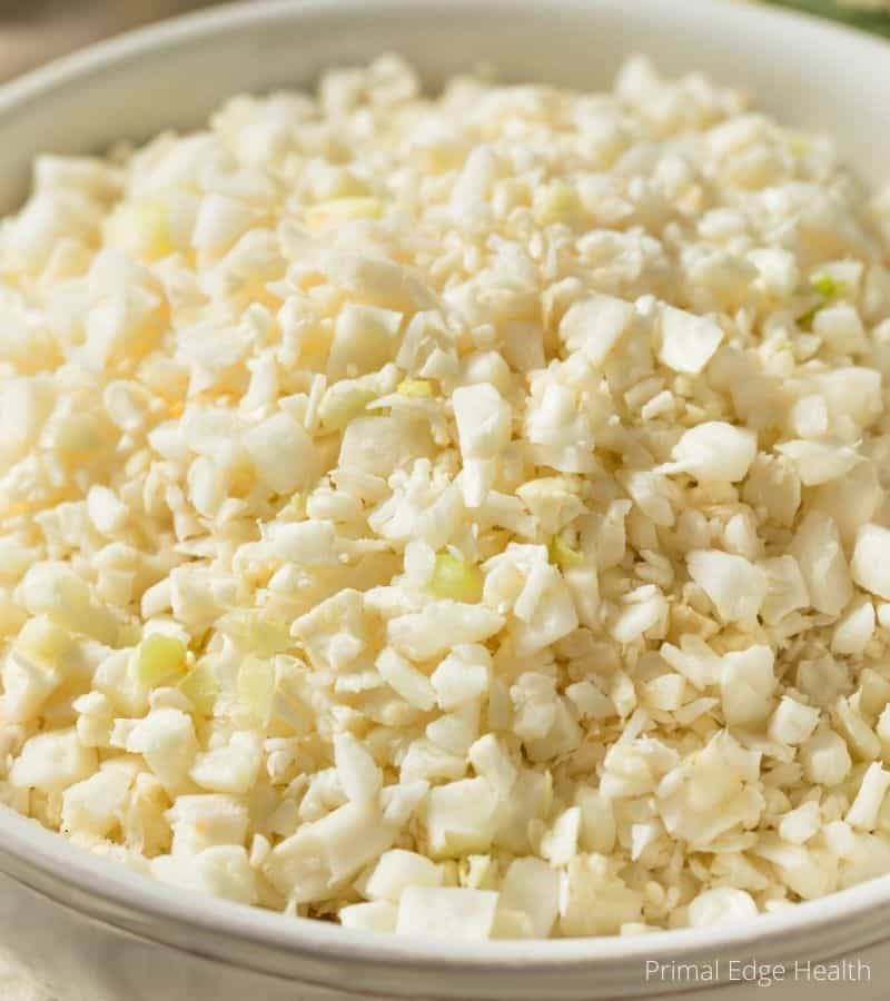 Uncooked cauliflower rice in a bowl.