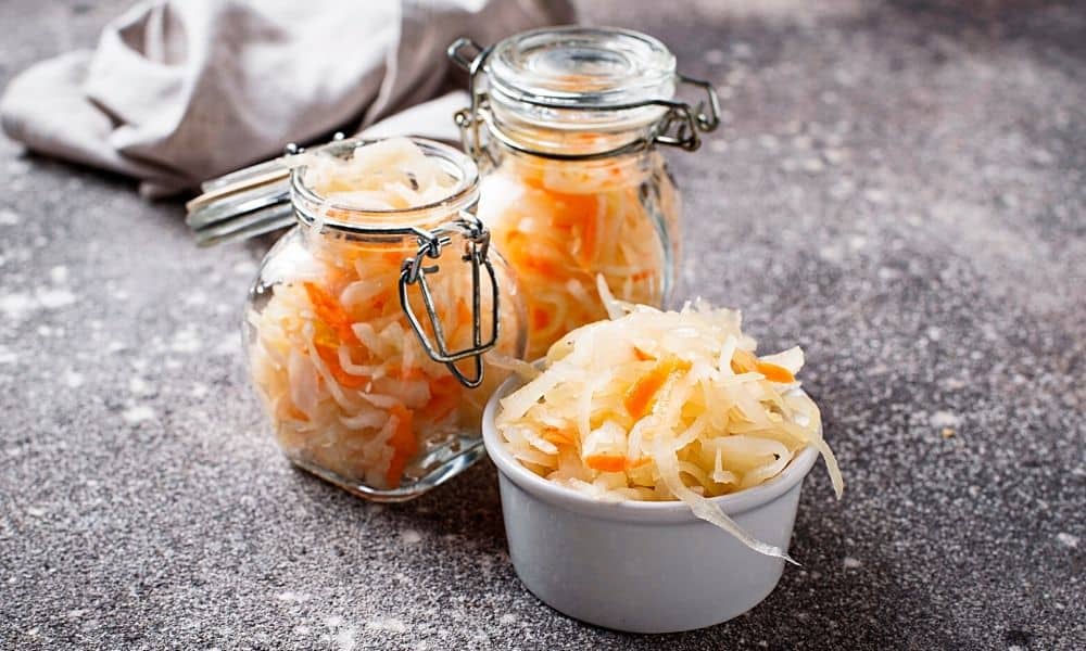 Homemade sauerkraut in mason jars and small bowl.