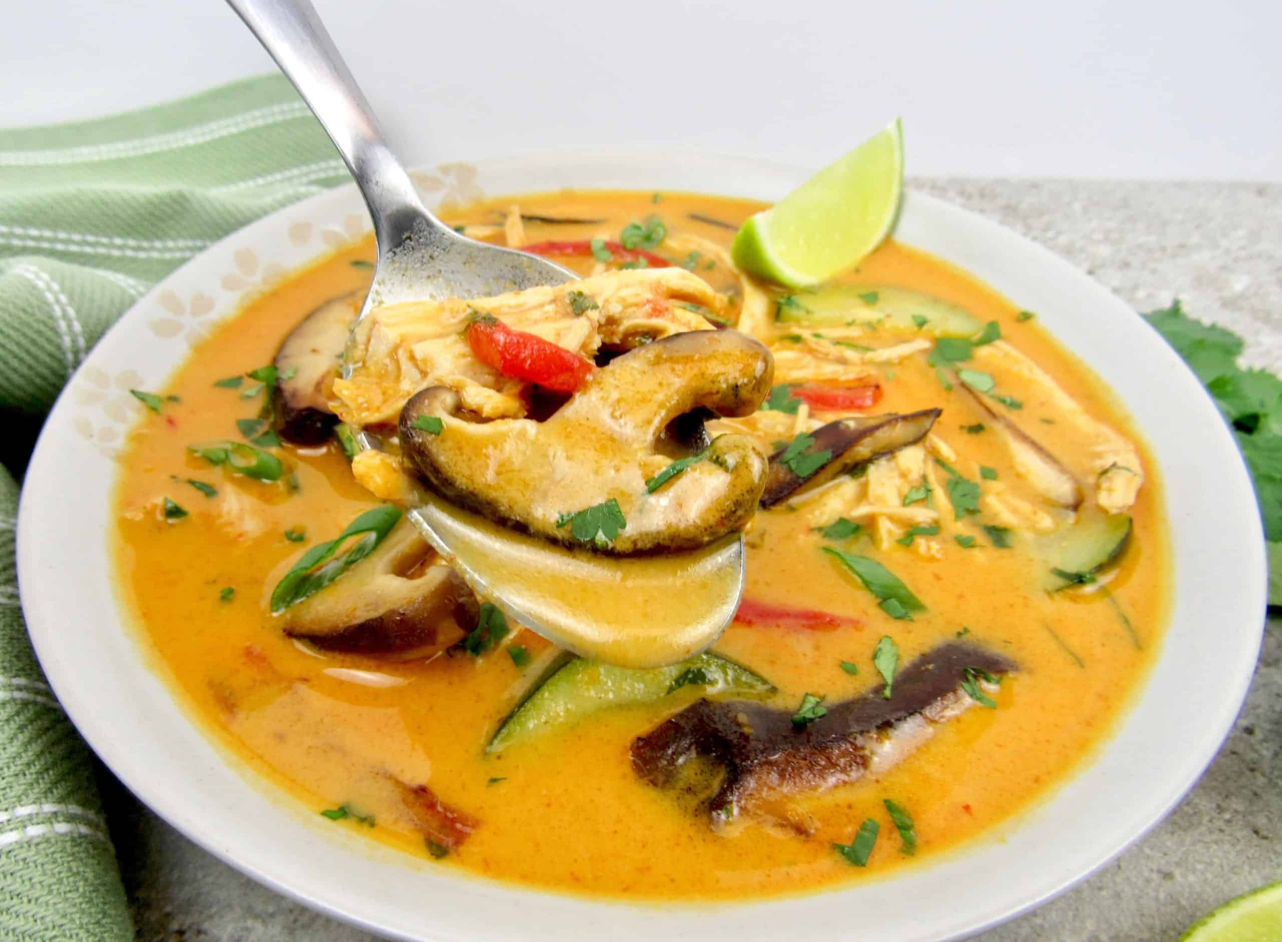 Thai coconut chicken curry soup in a white bowl.
