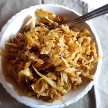 Braised cabbage recipe in a bowl with a spoon.