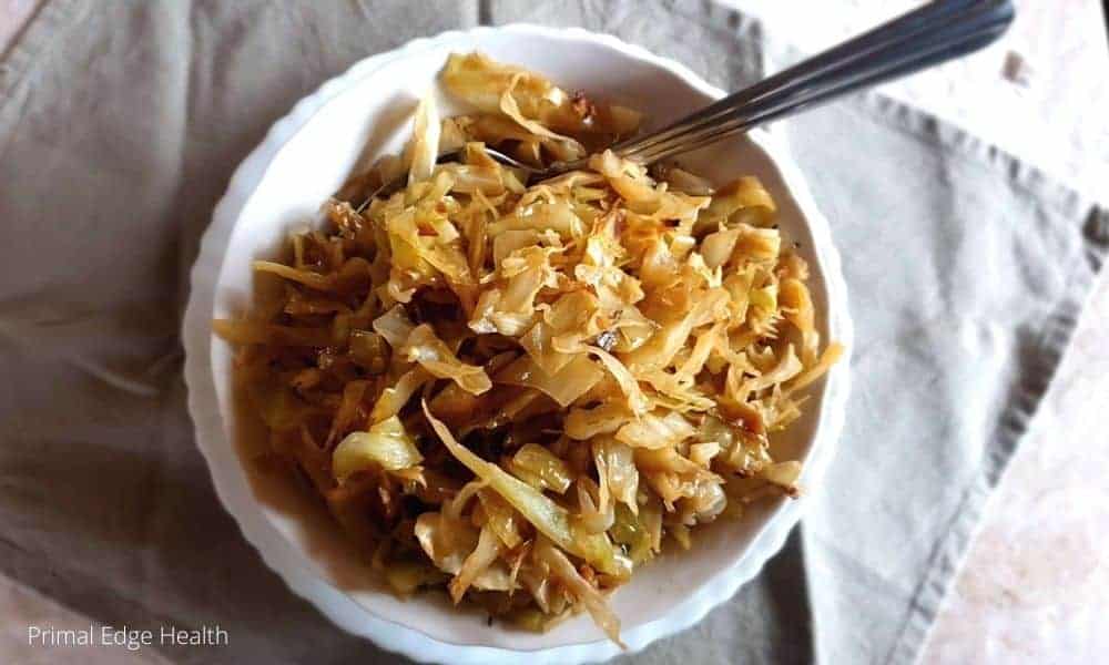 Braised cabbage recipe in a bowl with a spoon.