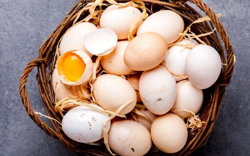 A batch of eggs in a brown woven basket.