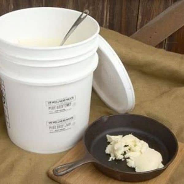 A white bucket of tallow and a pan.