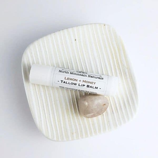Tallow lip balm on a white surface.
