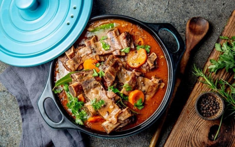 Beef stew low carb vegetables dinner in a black pot.