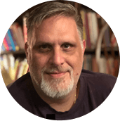 A picture of a man wearing a dark colored shirt.