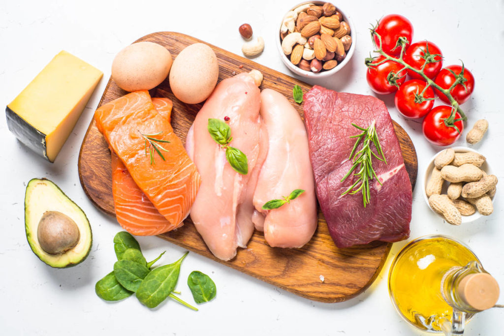 Various meat and vegetables laid out on a white surface.