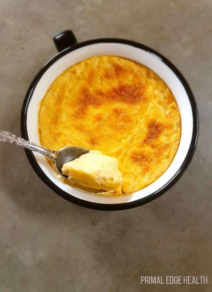A serving of low carb custard in a black and white mug.