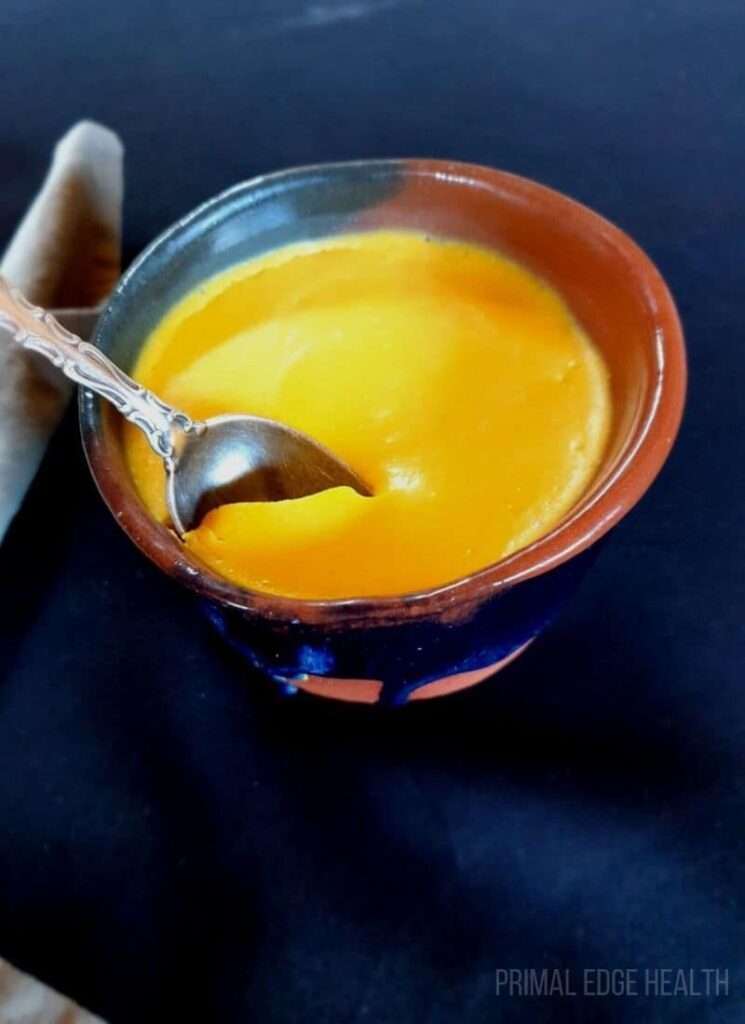 Egg pudding in a small bowl on a blue surface.