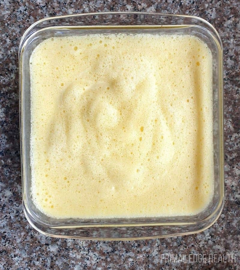 A square glass containing cake batter.