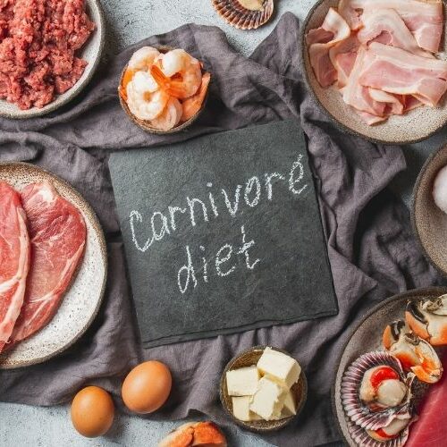 Carnivore Diet written on a surface surrounded by raw meat.