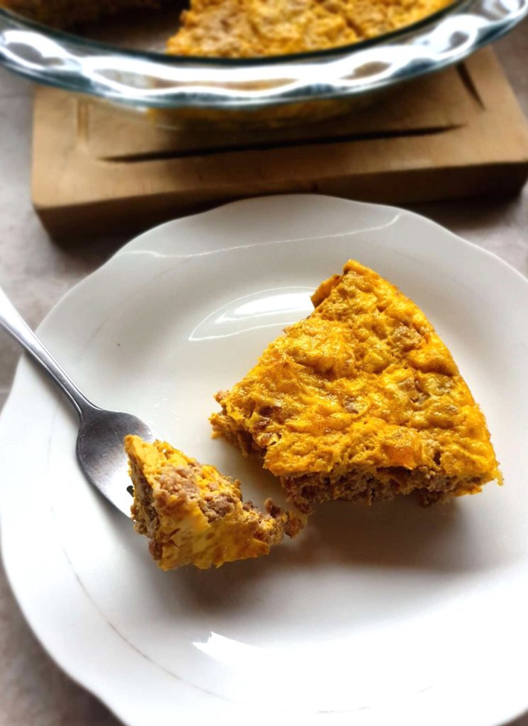 One slice of carnivore casserole on a plate with a fork.