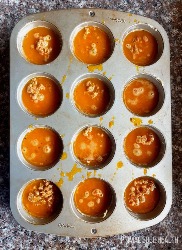 Baking tray with yellow liquid in each space.