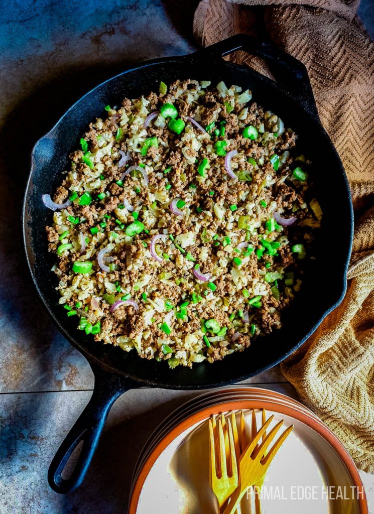 Dirty rice recipe ground beef in a black pan with wooden forks.