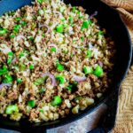 Dirty rice in a pan with a brown cloth.