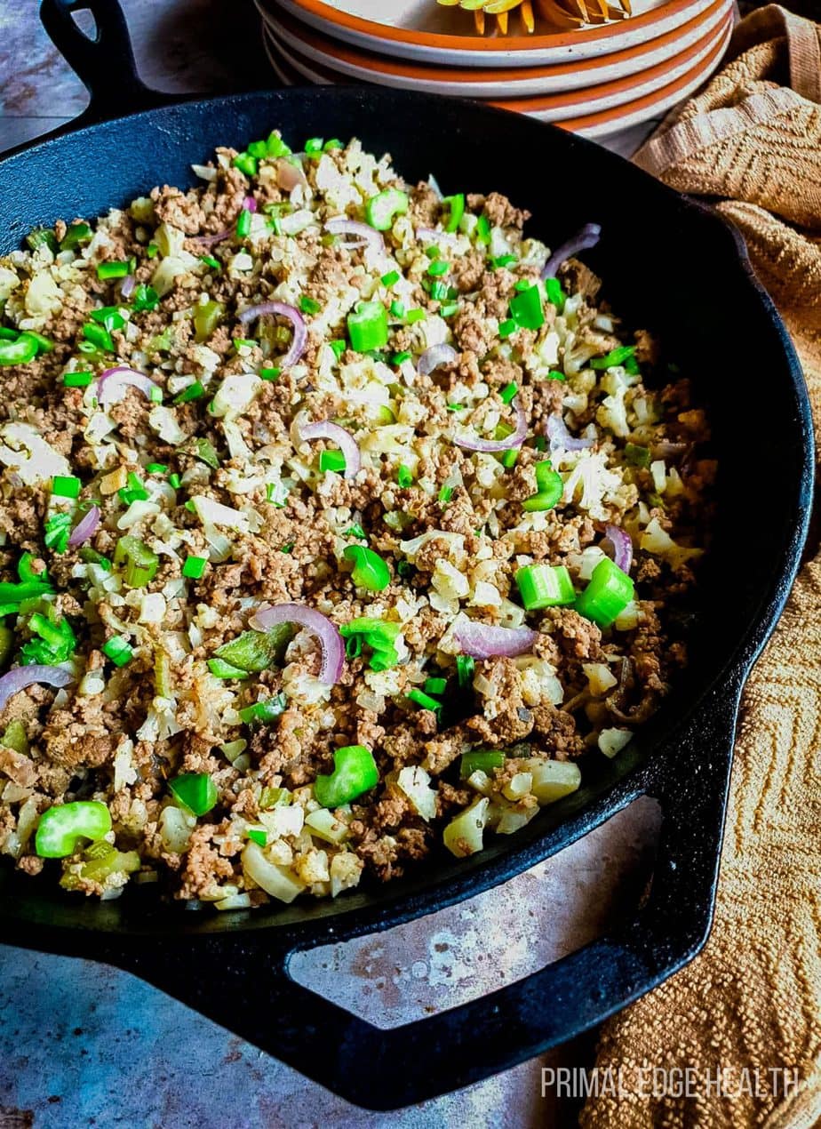 Dirty rice in a pan with a brown cloth.