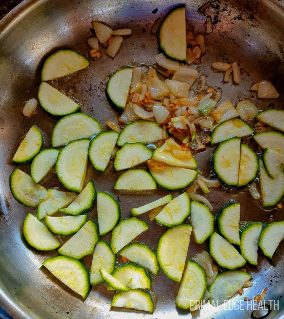 Vegetables being sauted in a pan.