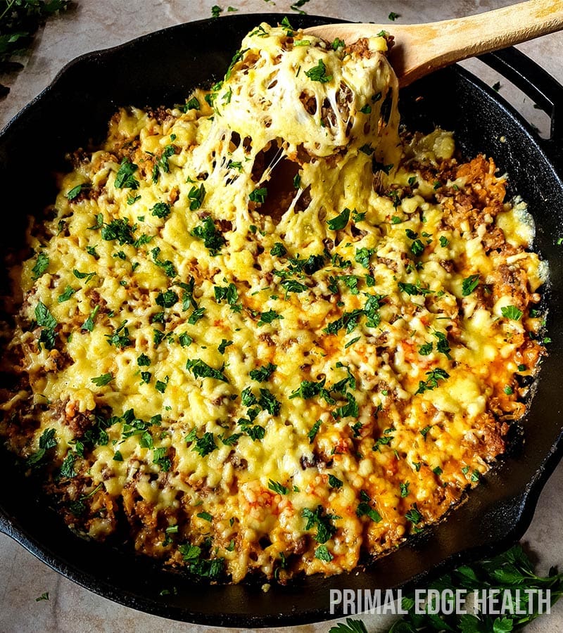 Italian ground beef in a skillet with a wooden spoon.
