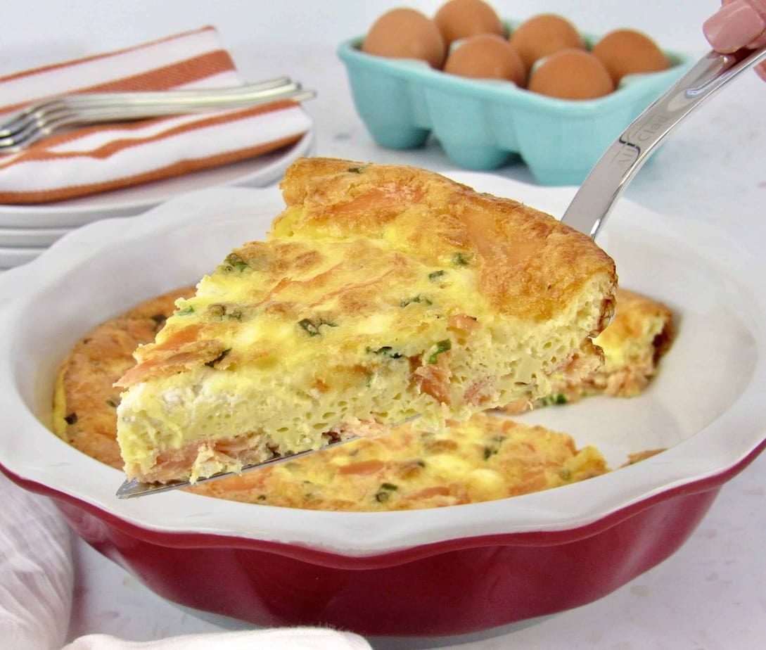 Keto Smoked Salmon Crustless Quiche with a slice being taken out of it.