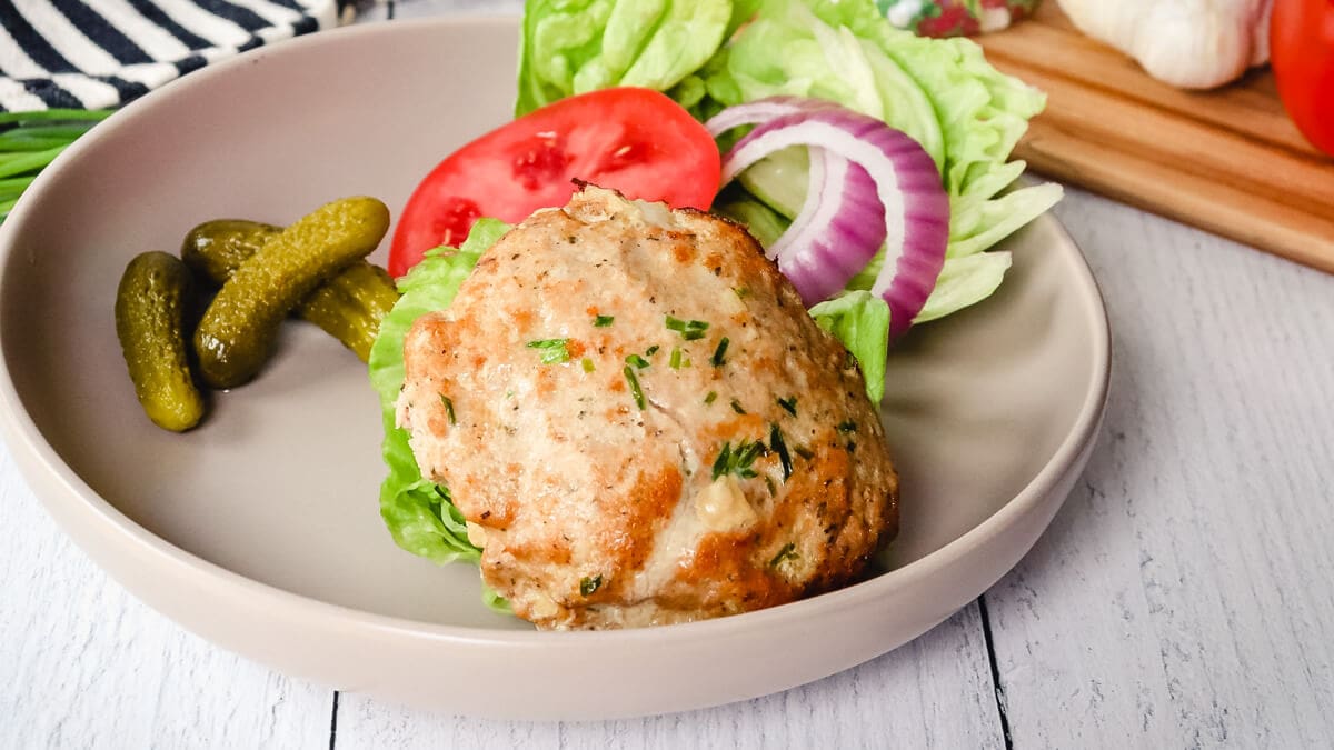 Keto Turkey Burger on a plate on a wooden surface.