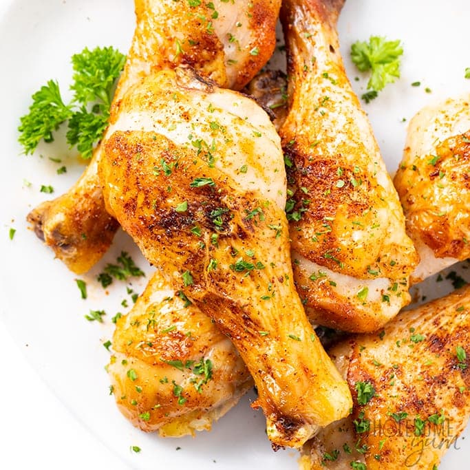 Chicken legs drumsticks on a white surface.