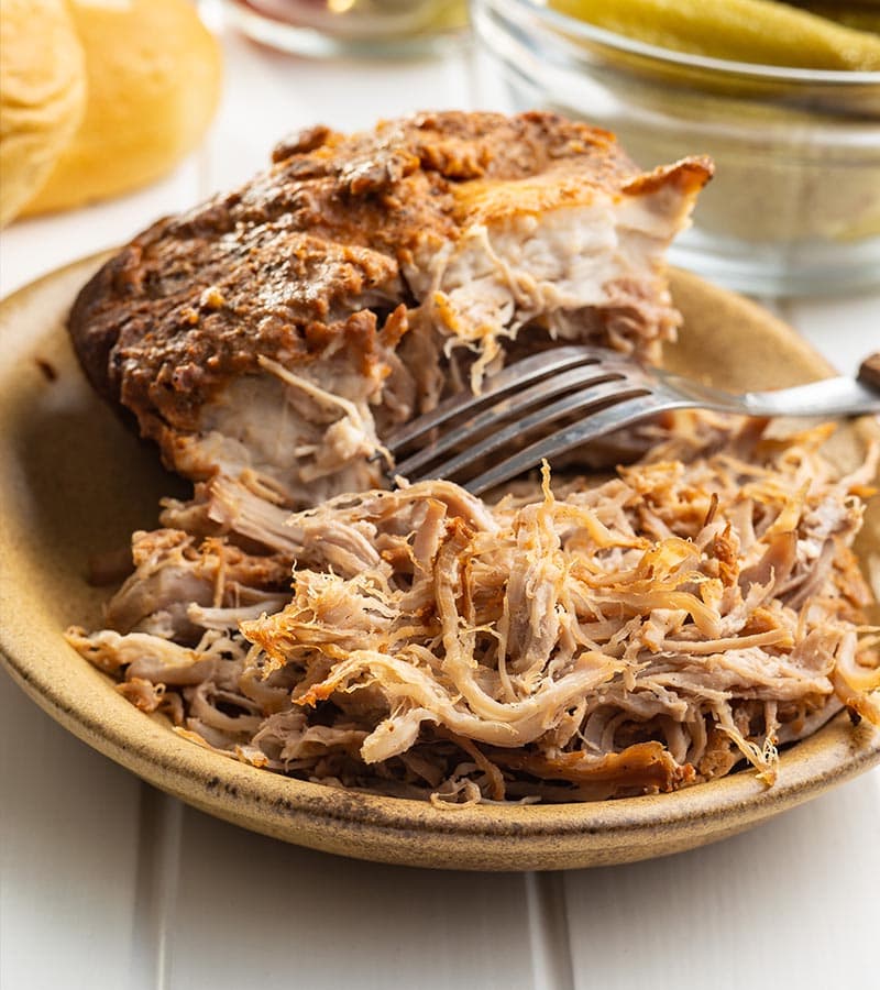Shredded chicken on a plate with a fork.