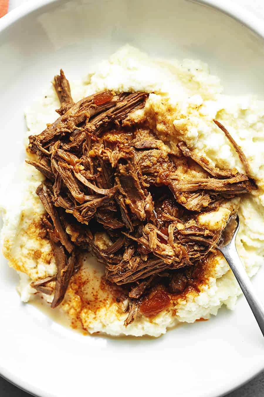 Slow cooker balsamic london broil on a white plate.