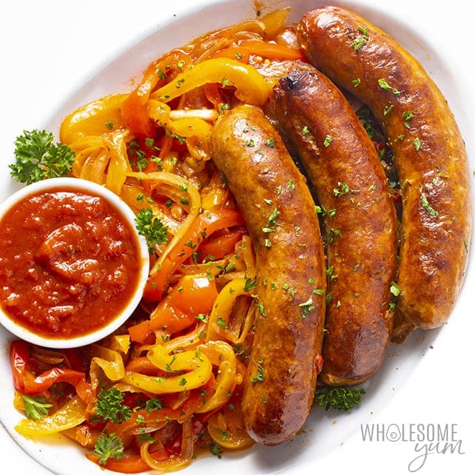 Wholesomeyum crock pot sausage and peppers on a white plate.