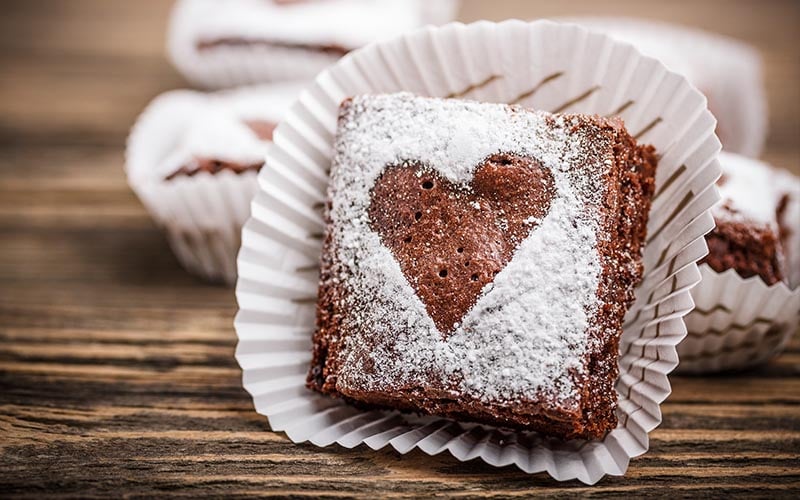 A piece of brownie on a wooden surface.