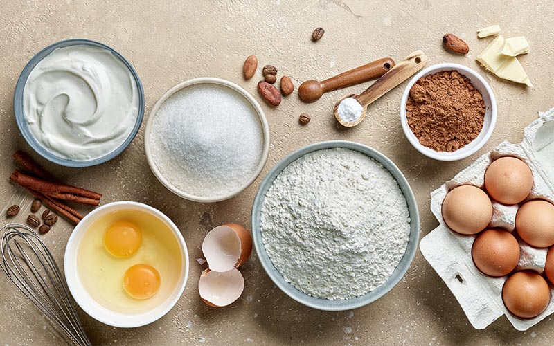 Raw ingredients for baking on a white surface.