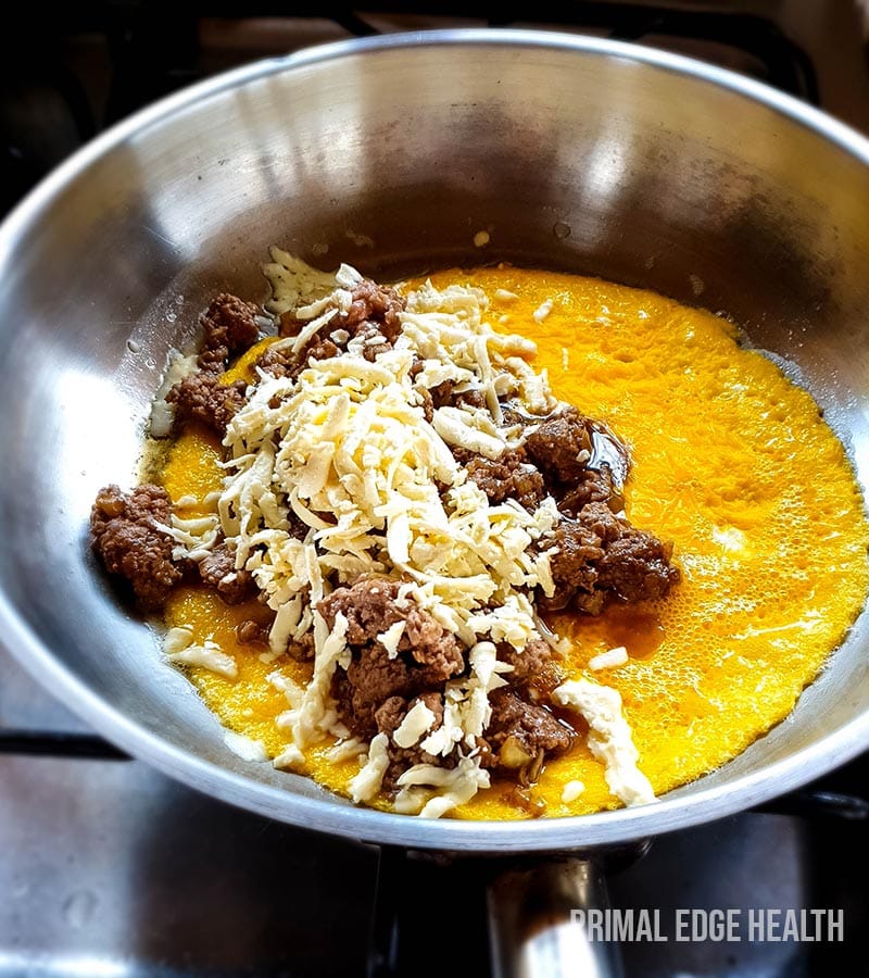 Meat, cheese and egg on a pan.