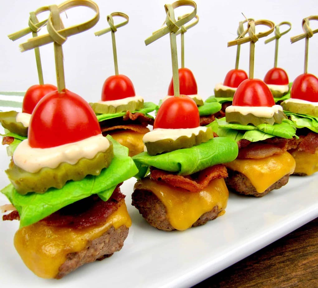 Bacon cheeseburger bites on a white plate.