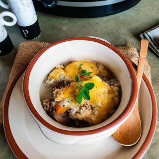 A bowl of keto shepherd's pie on a grey surface.