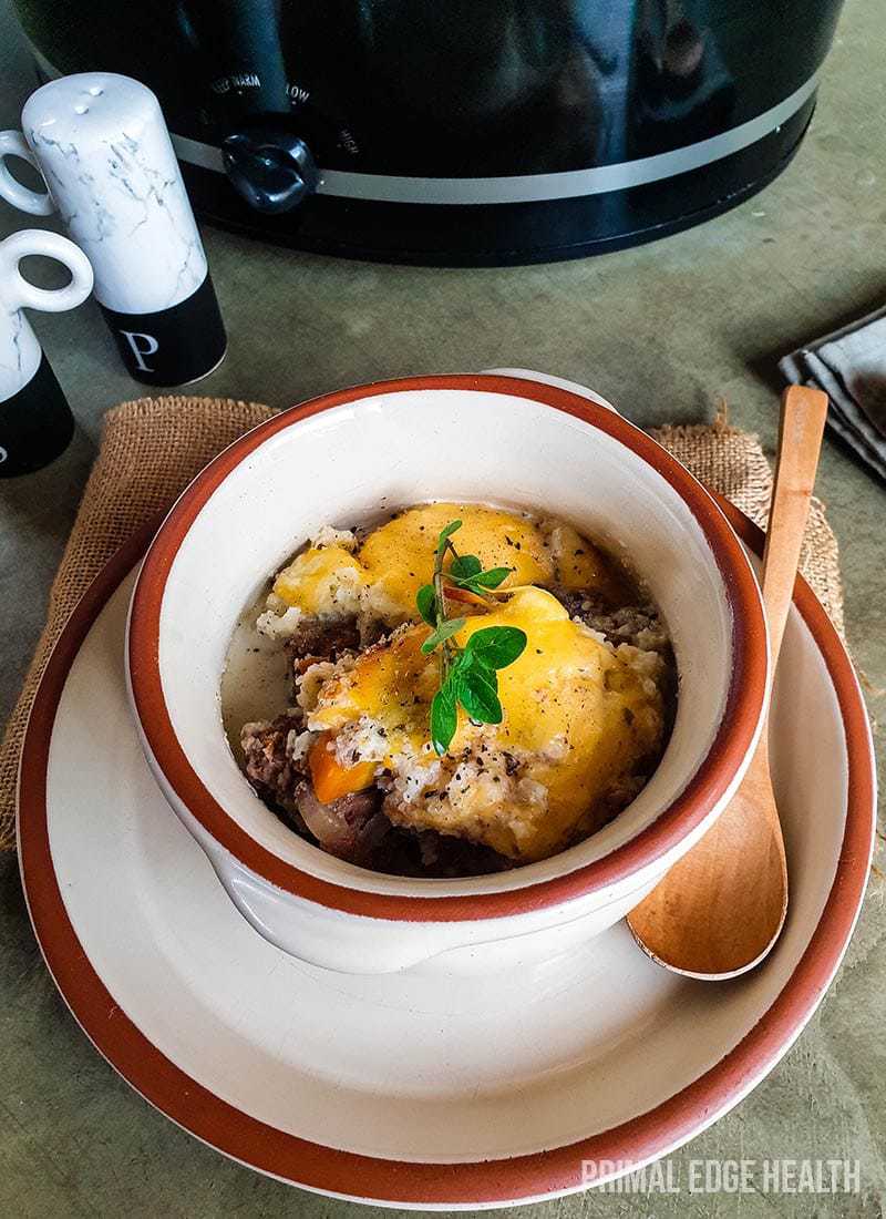 A bowl of keto shepherd's pie on a grey surface.