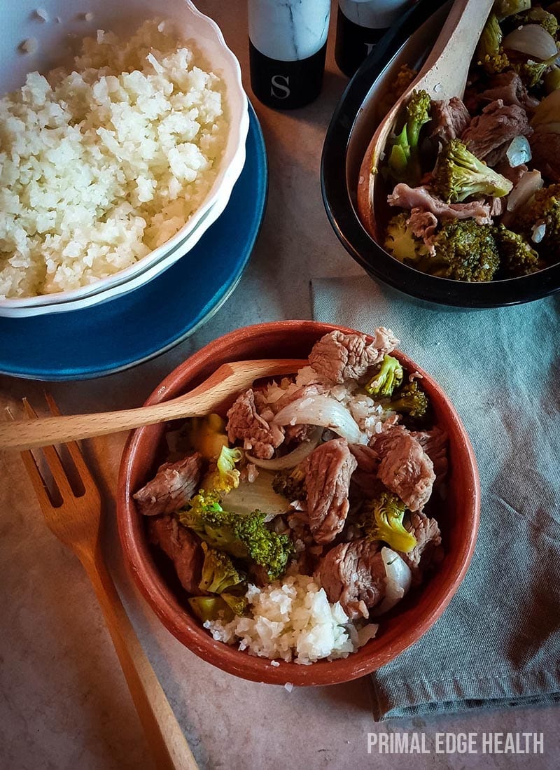 Beef and broccoli recipe in a bowl served with rice and wooden fork.