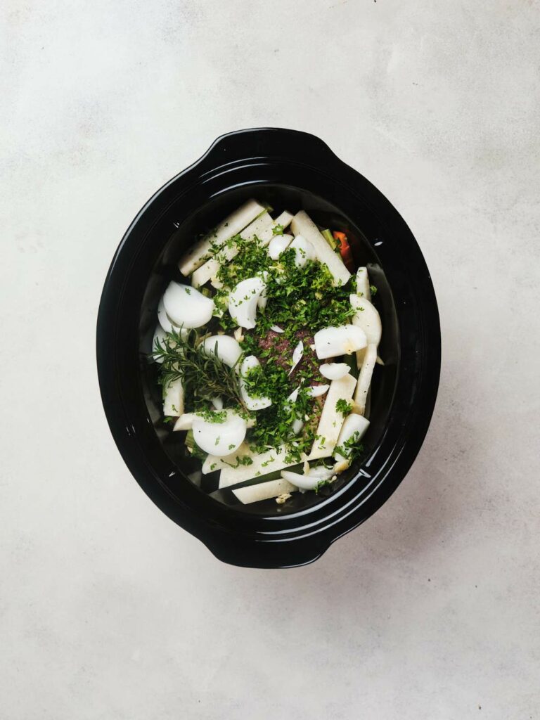 Slow cooker pot roast on a light grey background.