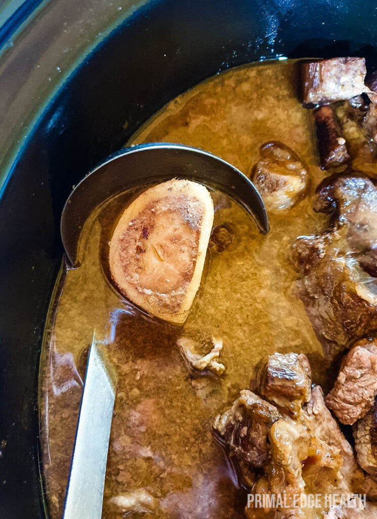 A pot of carnivore beef stew with a ladle.