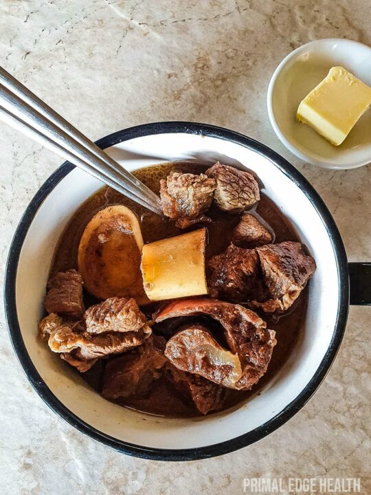 A cup of carnivore beef stew on a white surface.