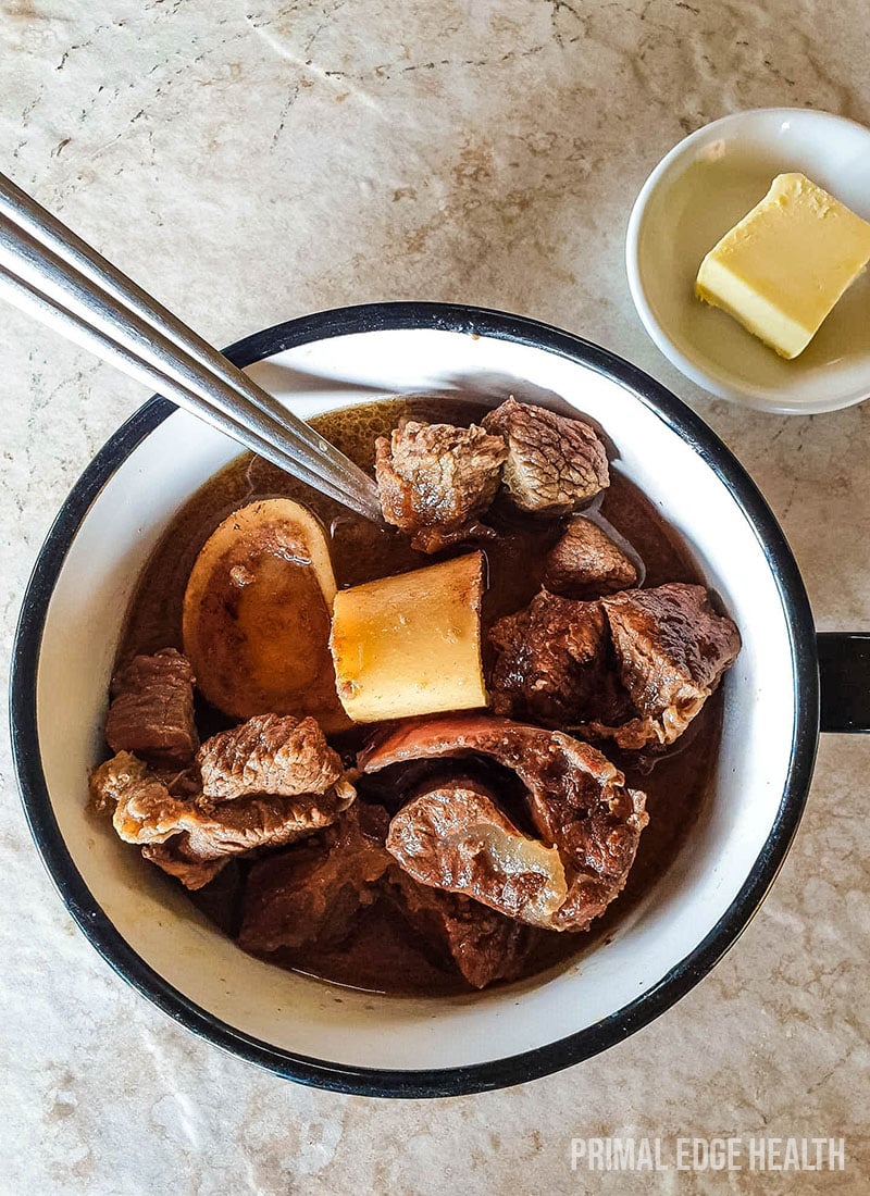 A cup of carnivore beef stew on a white surface.