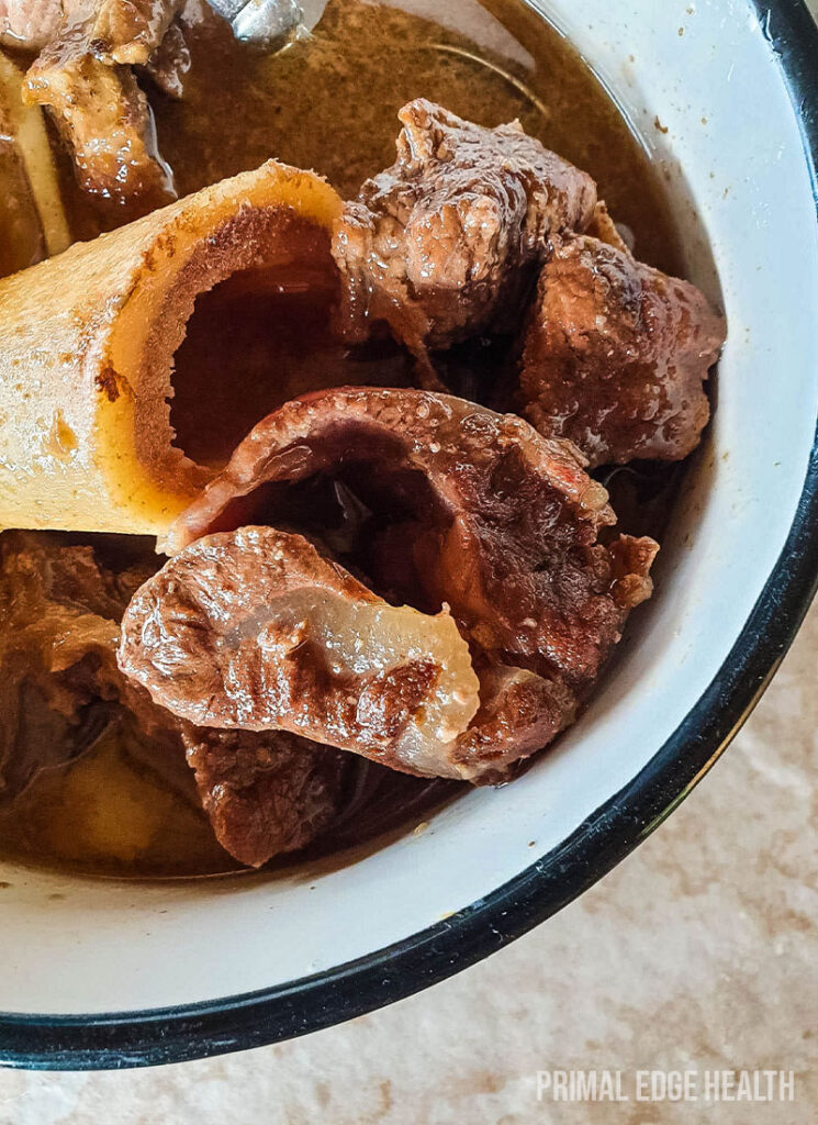 A serving of carnivore beef stew in a black and white bowl.