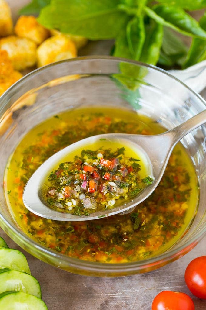 A serving of Italian dressing in a clear bowl.