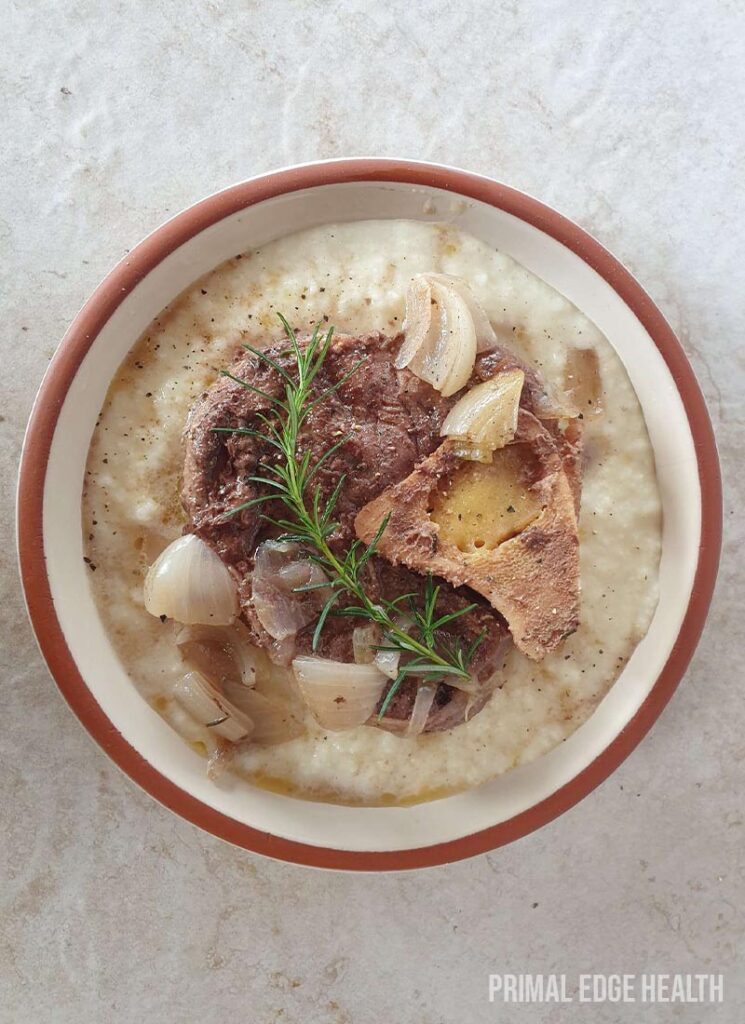 Beef shank cross cut with garnish in a bowl on a white surface.